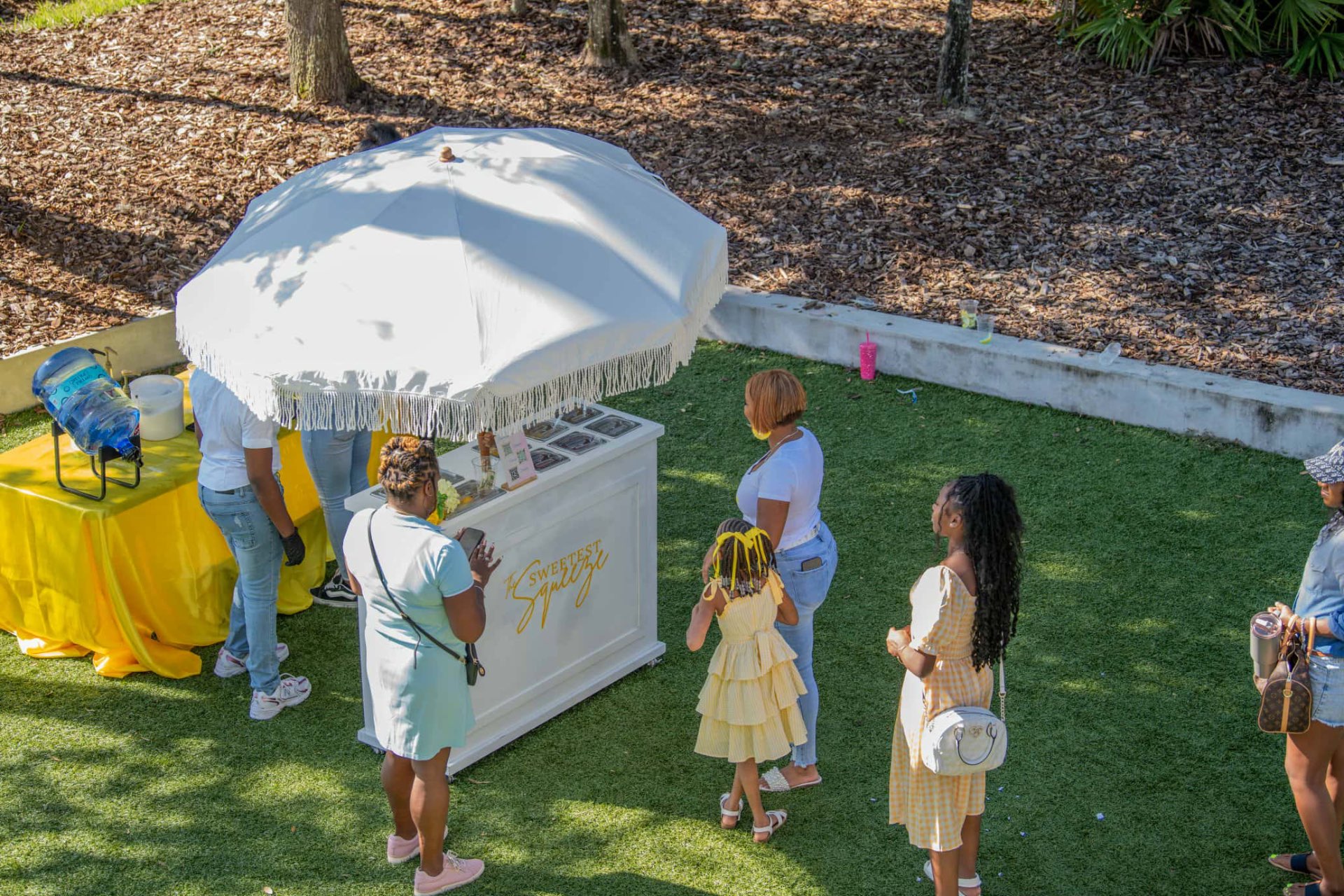 The Sweetest Squeeze lemonade cart with guests at an outdoor event